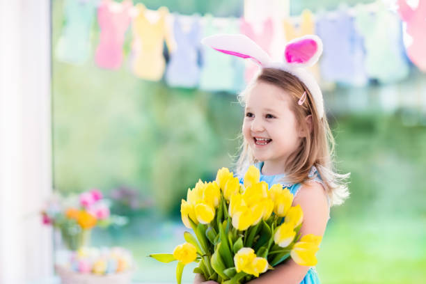 istock Little girl in bunny ears on Easter egg hunt 647474052