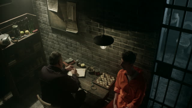 Guard interrogating men in prison