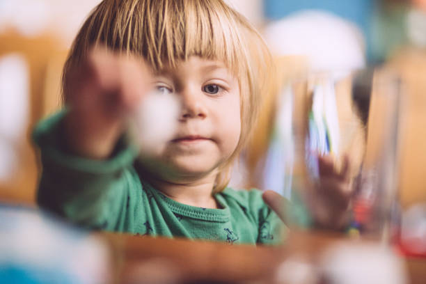 Blond Boy Playing With Toys On Morning At Bedroom