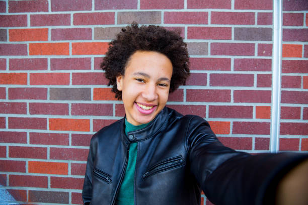 istock Smiling Teen Selfie Against Brick Wall 647487812