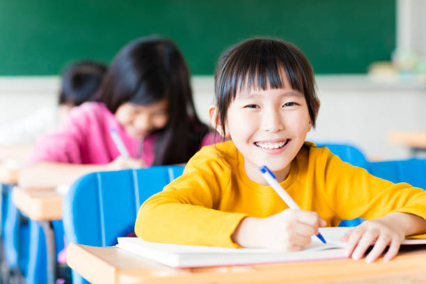 happy little girl student studying in the classroom - chinese ethnicity student china asian ethnicity imagens e fotografias de stock