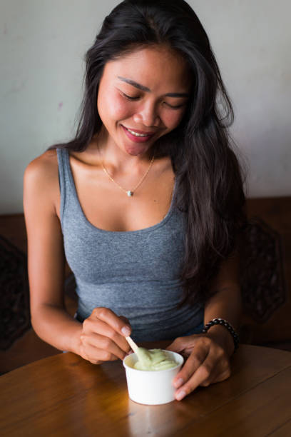 Young adult girl in yogurt cafe for breakfast and coffee