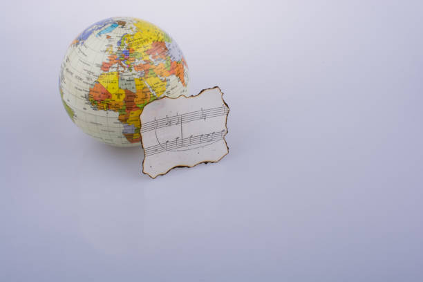 istock Musical notes on a burnt paper and a model globe 647507078