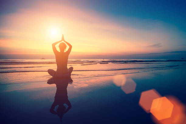 istock Woman doing meditation near the ocean beach. 647507864