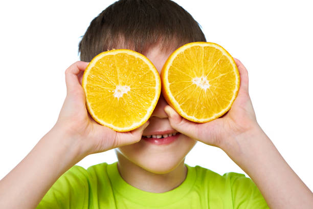 istock Happy boy with two slices orange isolated 647519710