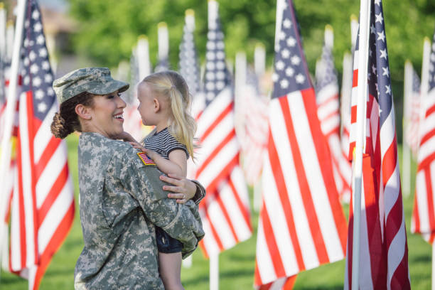 american female soldier with 3 year old girl - mother holding child pointing imagens e fotografias de stock