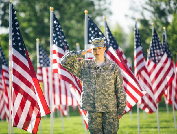 アメリカの女性兵士が星条旗のフィールドに敬礼 - armed forces latin american and hispanic ethnicity saluting marines ストックフォトと画像