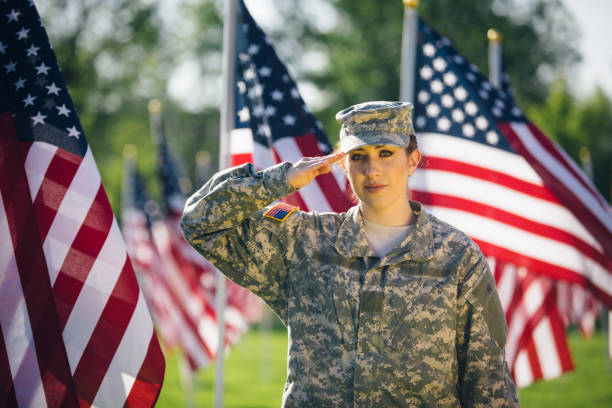 アメリカの女性兵士が星条旗のフィールドに敬礼 - armed forces latin american and hispanic ethnicity saluting marines ストックフォトと画像