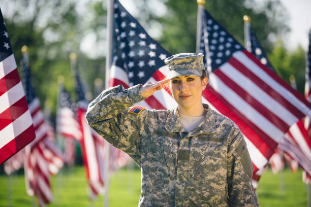 soldado americano feminino, saudando em um campo de bandeiras americanas - armed forces saluting marines military - fotografias e filmes do acervo