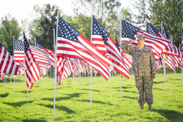 アメリカの女性兵士が星条旗のフィールドに敬礼 - armed forces latin american and hispanic ethnicity saluting marines ストックフォトと画像