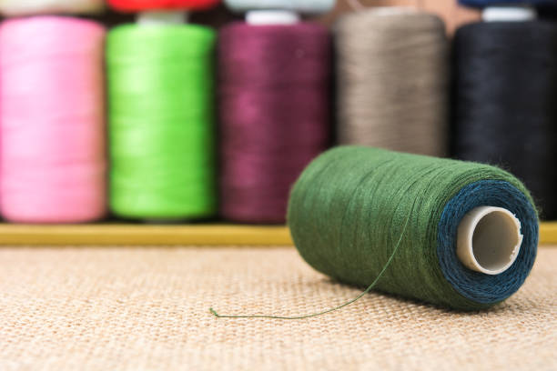 istock Dark green spools of thread on sackcloth 647534578