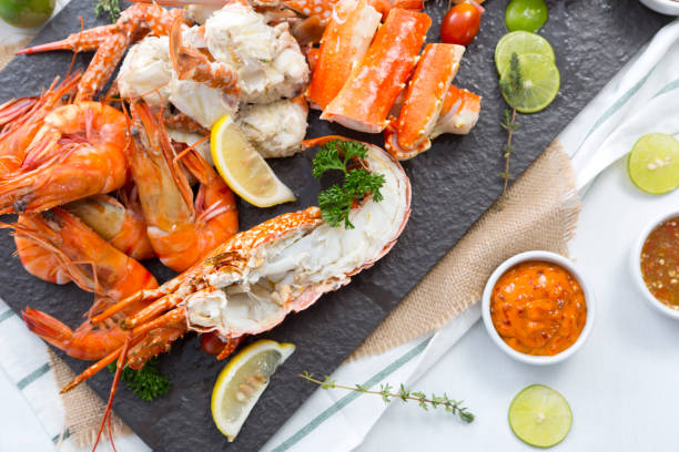 boiled prawn and lobster on stone plate boiled prawn and lobster on stone plate with spicy sauce and lime lobster seafood photos stock pictures, royalty-free photos & images