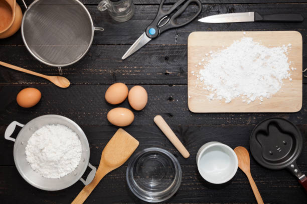 istock flour sprinkled with different wooden kitchen tools on black wood 647545214