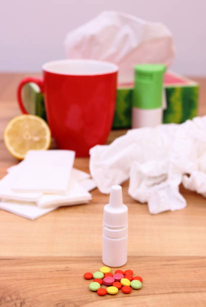 istock Pills and nose drops for colds, used handkerchiefs and tea 647548248