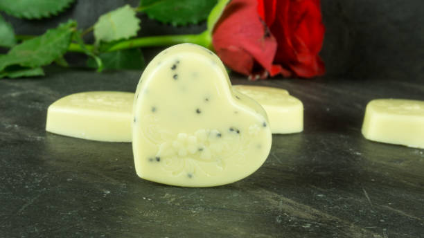 istock Red rose on slate with a heart of chocolate 647549286