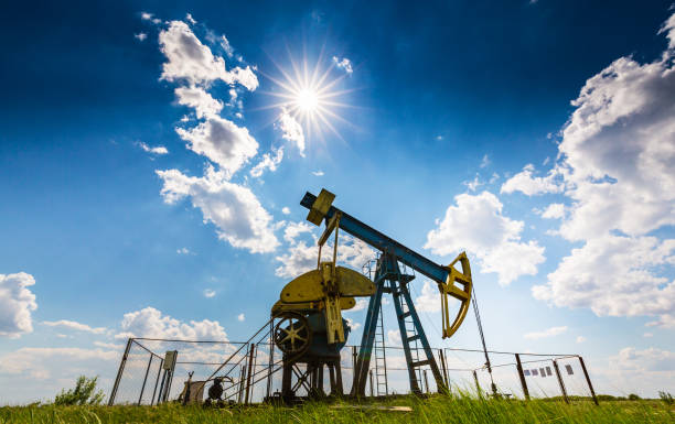 istock Oil field with pump jack, profiled on blue sky with white clouds, on a sunny day 647551690