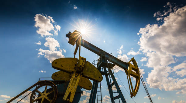 istock Oil field with pump jack, profiled on blue sky with white clouds, on a sunny day 647551960
