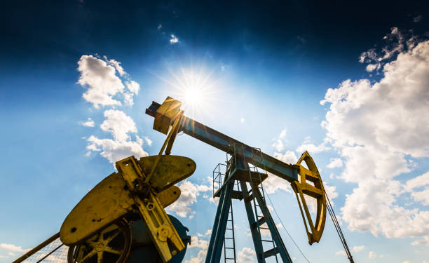 istock Oil field with pump jack, profiled on blue sky with white clouds, on a sunny day 647552018