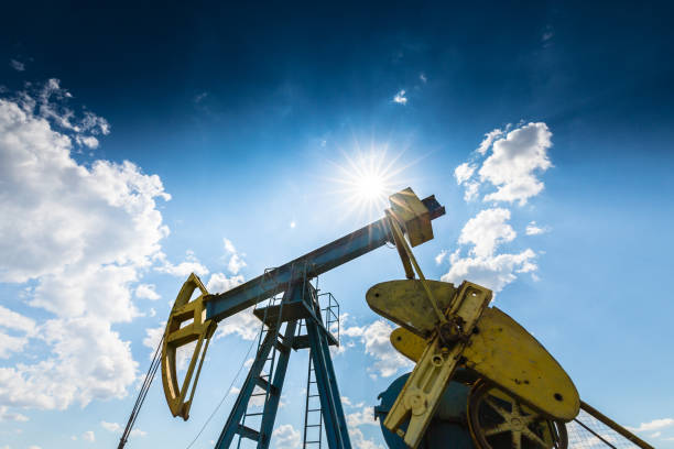 istock Oil field with pump jack, profiled on blue sky with white clouds, on a sunny day 647552022