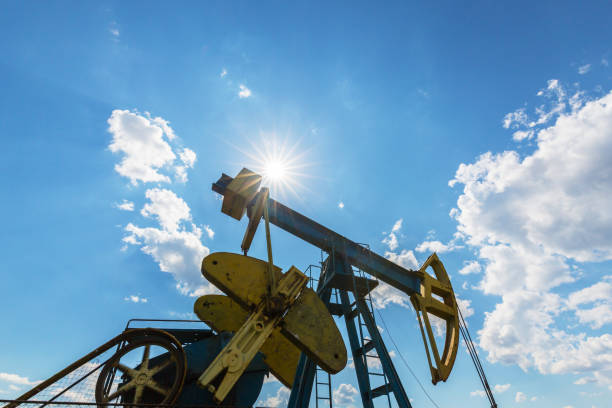 istock Oil field with pump jack, profiled on blue sky with white clouds, on a sunny day 647552048