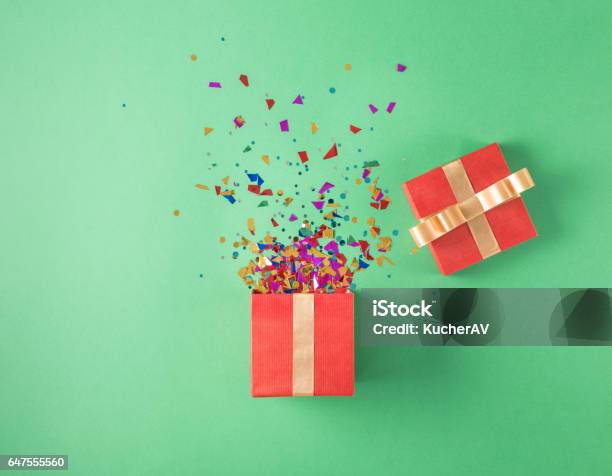 Open Red Gift Box With Various Party Confetti On A Green Background Stock Photo - Download Image Now