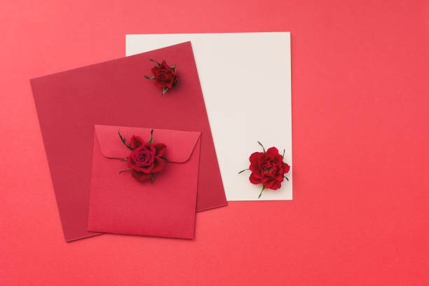 istock Red roses with a blank greeting card and envelope on paper background 647560272