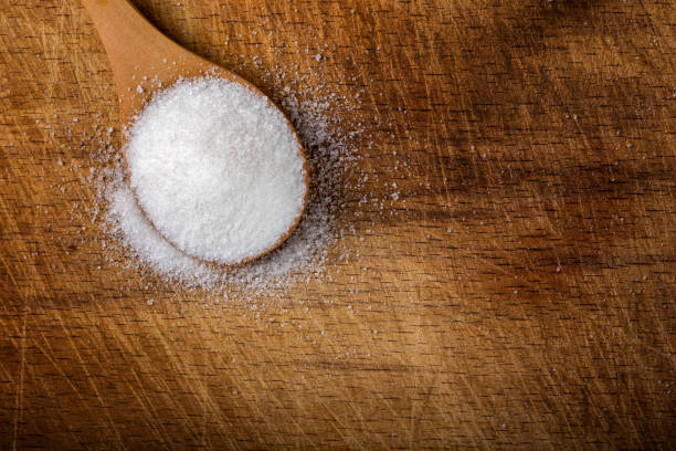 istock One bamboo spoon filled with white sugar on wood 647563744