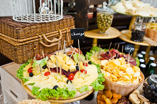 Diferrent cheese, chips, meat and salads on wedding reception.