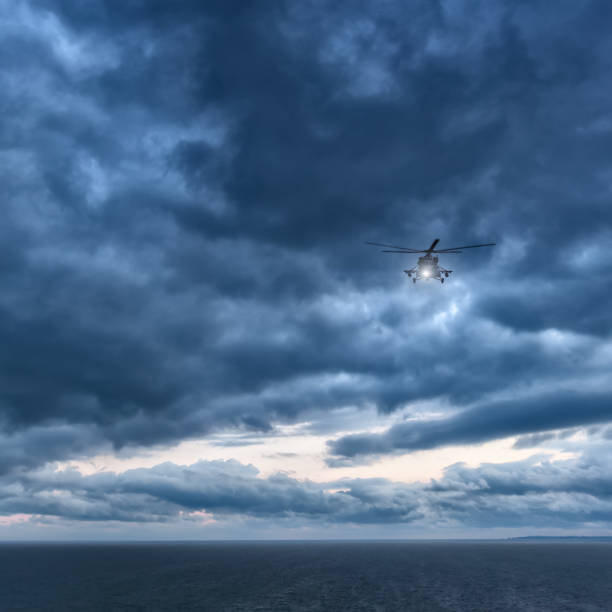 storm at sea, helicopter from below in front dramatic sky, stormy sky - rescue helicopter water searching imagens e fotografias de stock