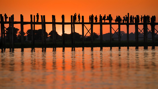 Silhouette fo people walking during sunset at U Bein Bridge, Mandalay, Myanmar