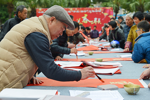 Feb 3rd,Foshan,China,the Spring Festival is approaching, people wrting Spring Festival couplets in order to prepareing for the lunar Spring Festival. For the festive air, people like using gold powder in writing words. Spring Festival couplets in Chinese means the good luck things. It’s said that, it can bring fortune and can look as a good omen.