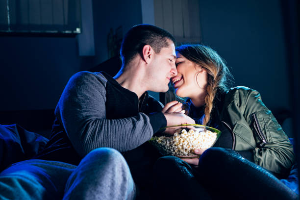 istock Couple watching movie,eating popcorn, sharing tanderness 647570702
