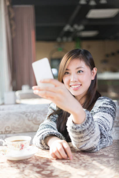 istock young pretty woman sits in cafe 647574278