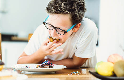 Happy boy eating delicious donut