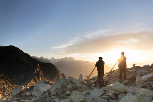 schweizer musiker spielen traditionelle horn an der spitze des mount eggishorn bei sonnenaufgang. - glacier aletsch glacier switzerland european alps stock-fotos und bilder