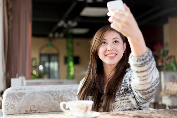 istock young pretty woman sits in cafe 647585676