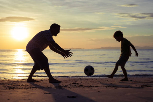 istock Father and son playing on the beach at the sunset time. 647585940