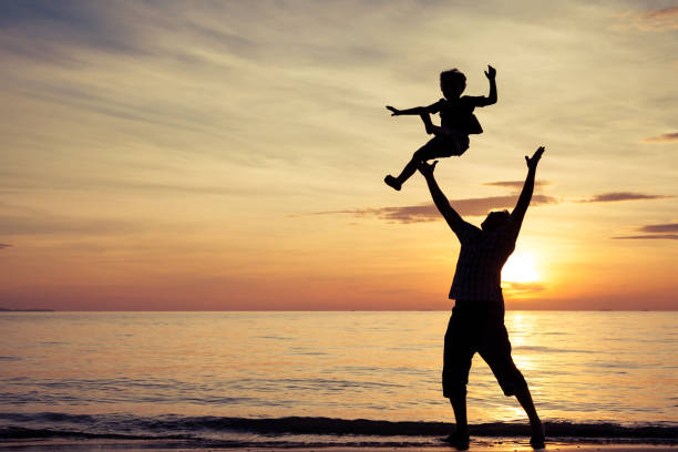 istock Father and son playing on the beach at the sunset time. 647585994
