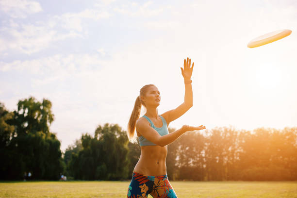 istock Young athletic girl playing with flying disc, ultimate 647588598