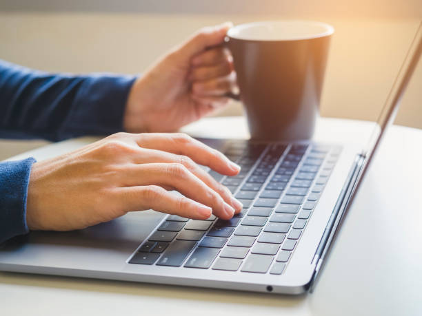 istock Woman hand typing on Laptop Keyboard with Coffee cup 647600072