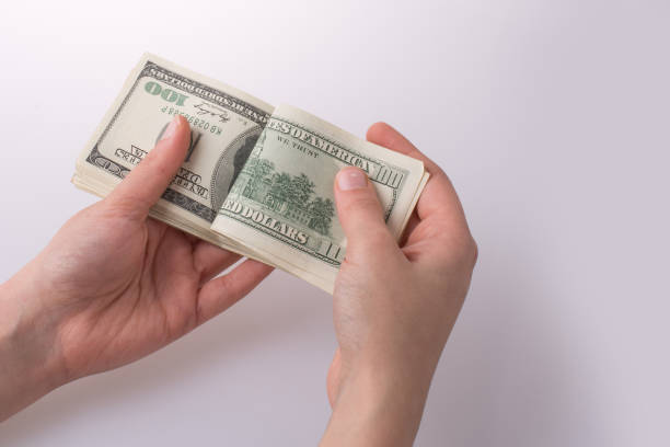 istock Human hand holding American dollar banknotes on white background 647600454