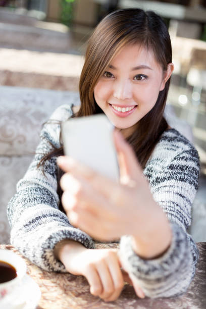 istock young pretty woman sits in cafe 647607578