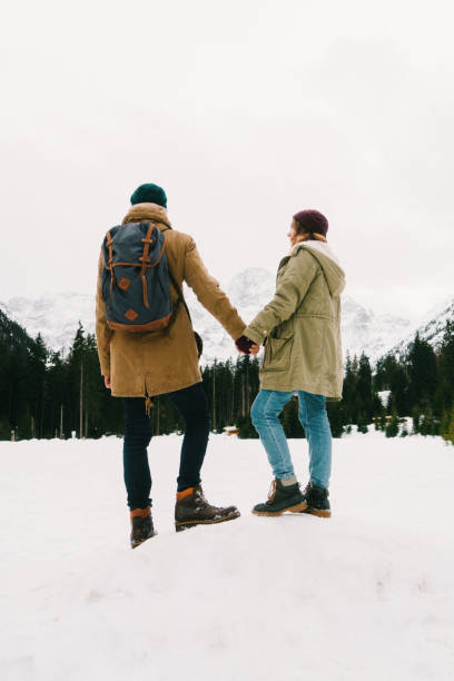 istock Couple standing in forest in mountains in winter 647611610