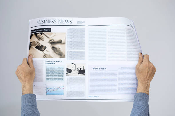 istock Man holding reading newspaper on gray background 647618780