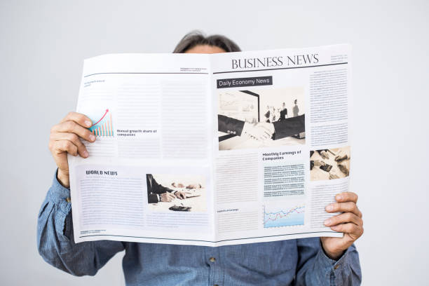 istock Man holding reading newspaper on gray background 647618844