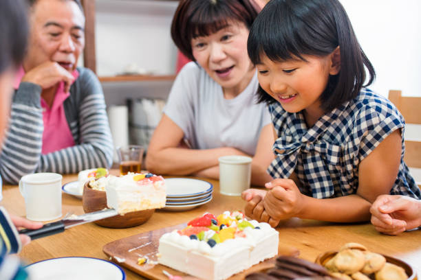 istock Young girl looking excitedly at cake as it's being cut 647623412