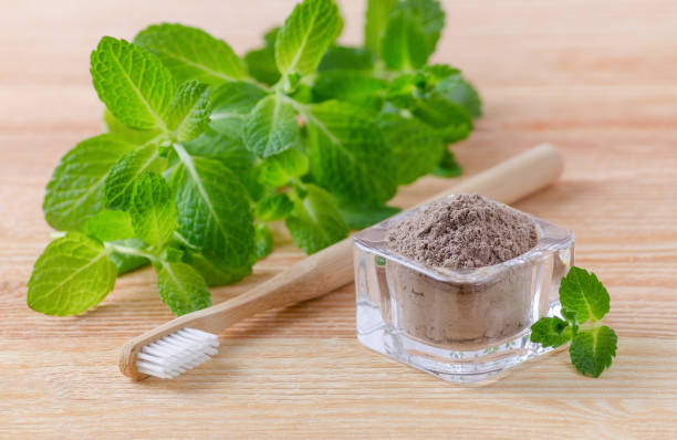 istock alternative natural toothpaste clay, ash and wood toothbrush, mint on wooden 647629834
