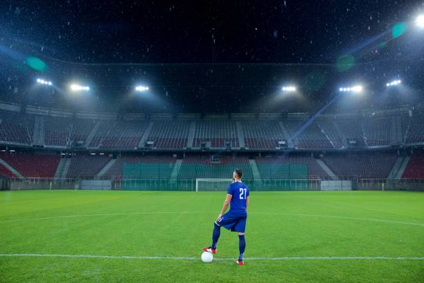 istock Football player standing in stadium 647629930