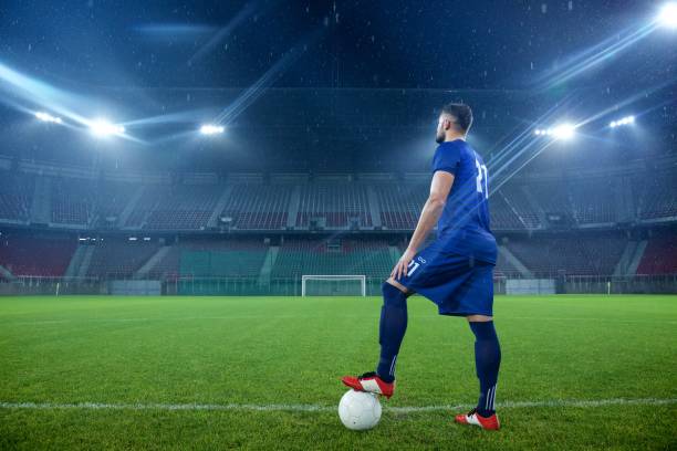 istock Football player standing in stadium 647629934