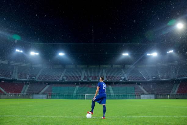 футболист, стоящий на стадионе - soccer field night stadium soccer стоковые фото и изображения